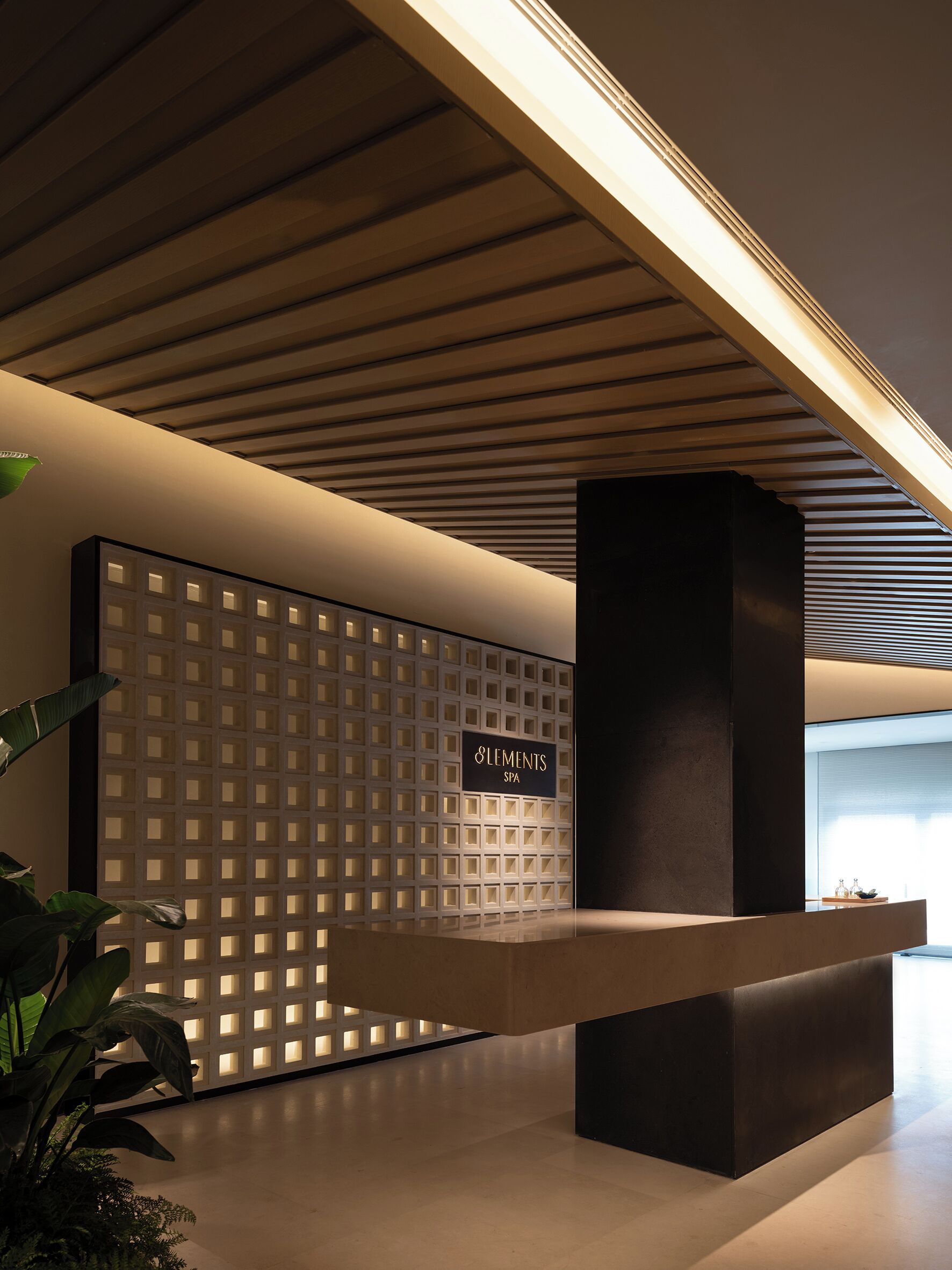 Un'area reception dal design moderno, con soffitto in legno, una scrivania reception e un parete con motivo a griglia.