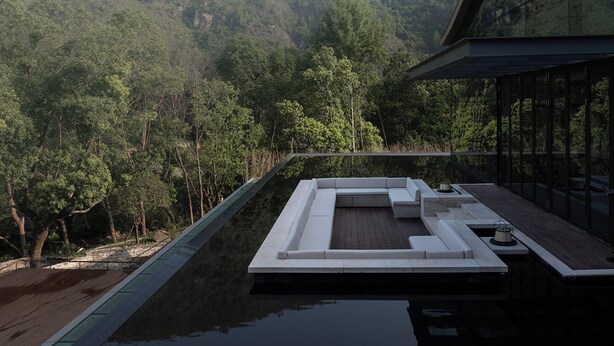A modern outdoor pool area with a seating area and a view of a forested hillside. - Garrya Xianju (Taizhou)