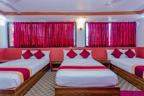 A hotel room with three beds, red curtains, and a patterned floor. - Hotel Aakansh (Sainbu)