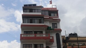 A multi-story building with balconies and a flag. - Hotel Aakansh (Sainbu)