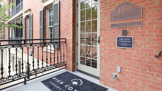 A brick building with a sign reading "1300 Van Buren Avenue" and "Owners Only." A doormat with "High Cotton Condominium" is visible.
