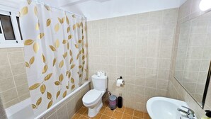 Casa de banho com sanita, bidé e lavatório.