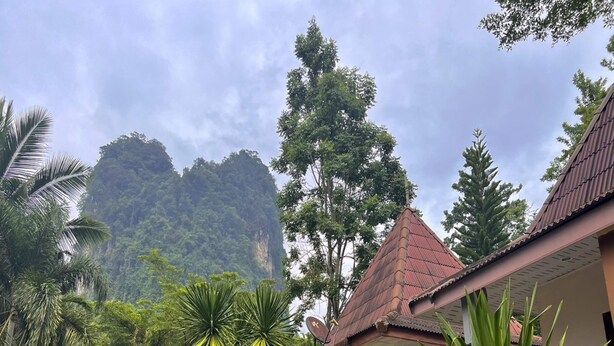 A building with a red roof and a staircase leading to a balcony. - OYO 75517 Mananchaya Resort (Ao Luek)