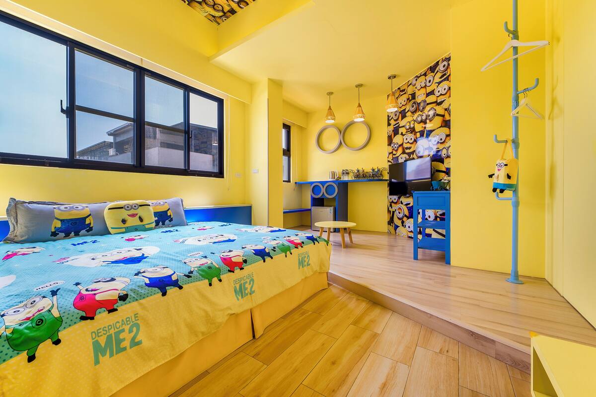 Ein Zimmer mit einem großen Bett, einem Schreibtisch, einem Stuhl und einem Fenster.