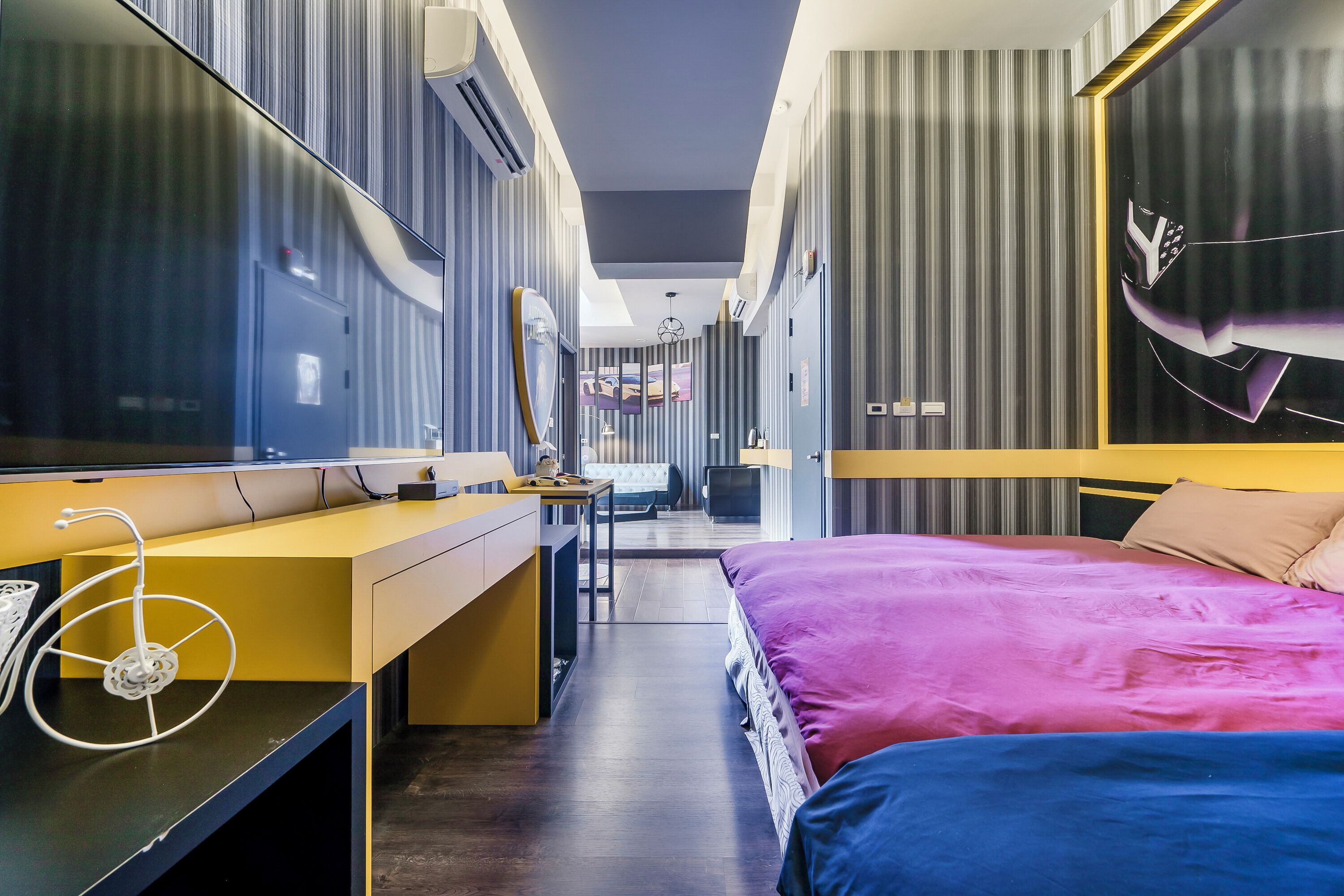 Una habitación de hotel moderna con una cama grande, un escritorio y un espejo.
