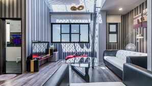 Ein modernes Wohnzimmer mit einem Glastisch, einer Couch und einem Fernseher.