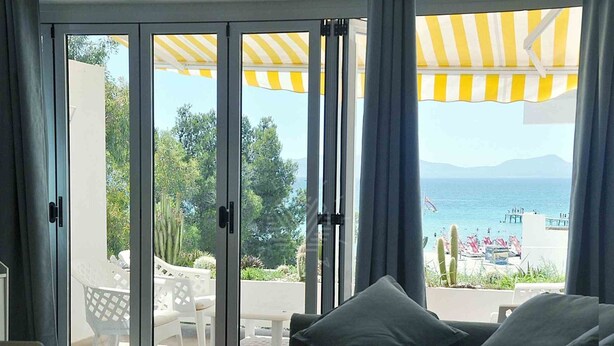 A room with a sofa and a view of the sea through large sliding glass doors. - Beachfront · Terrace · Adults Only (Alcudia - Puerto de Alcudia)
