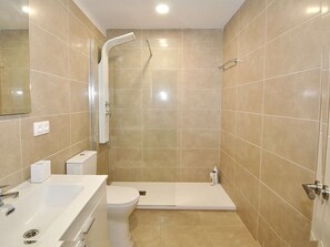 Une salle de bain moderne équipée d’une douche, de toilettes et d’un lavabo.