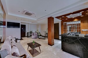 Un vestíbulo moderno con sofá, mesa de centro y mostrador de recepción.