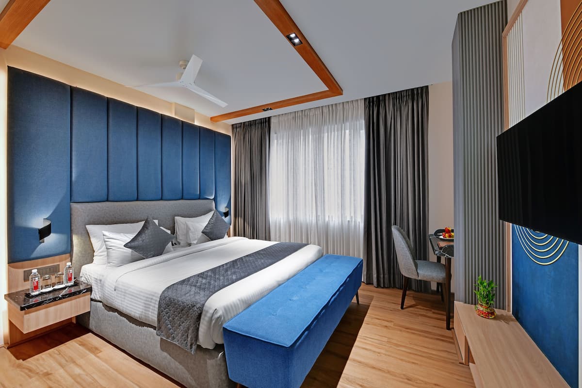 Ein modernes Schlafzimmer mit einem großen Bett, einem Schreibtisch und einem Fernseher.