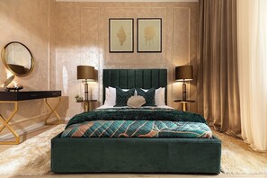 A bedroom with a large bed, two bedside lamps, a round mirror, a desk, and two framed pictures on the wall.