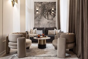 A modern living room with a sofa, two armchairs, a coffee table, and a large wall art piece. - Qult·co - Legends of the Fall (București)
