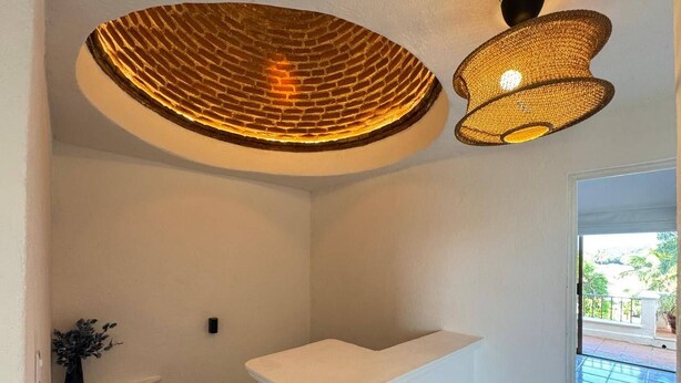 A bathroom with a white sink, a shower area, and a ceiling light fixture. - Luxury Condo Overlooking Marina in Ixtapa (Ixtapa)