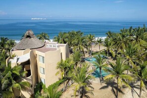A resort with a pool, palm trees, and a beach view. - Your Private Piece of Mexican Beachfront Luxury (Playa Blanca)