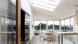 A modern kitchen with a skylight, large windows, and a dining area with a view.