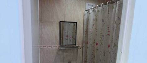 Une petite salle de bain avec des toilettes, un lavabo et un rideau de douche.