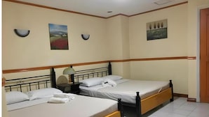 Habitación de hotel con dos camas, una mesita de noche con lámpara y dos luces fijadas a la pared.