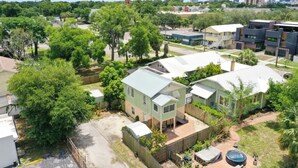 A residential area with houses, a fenced yard, and a clear sky. - 1920s Cottage Downtown, Ybor with Hot Tub! (Tampa)