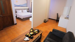 Une chambre d’hôtel avec un lit, une table à manger avec de la nourriture, une télévision et une salle de bain.