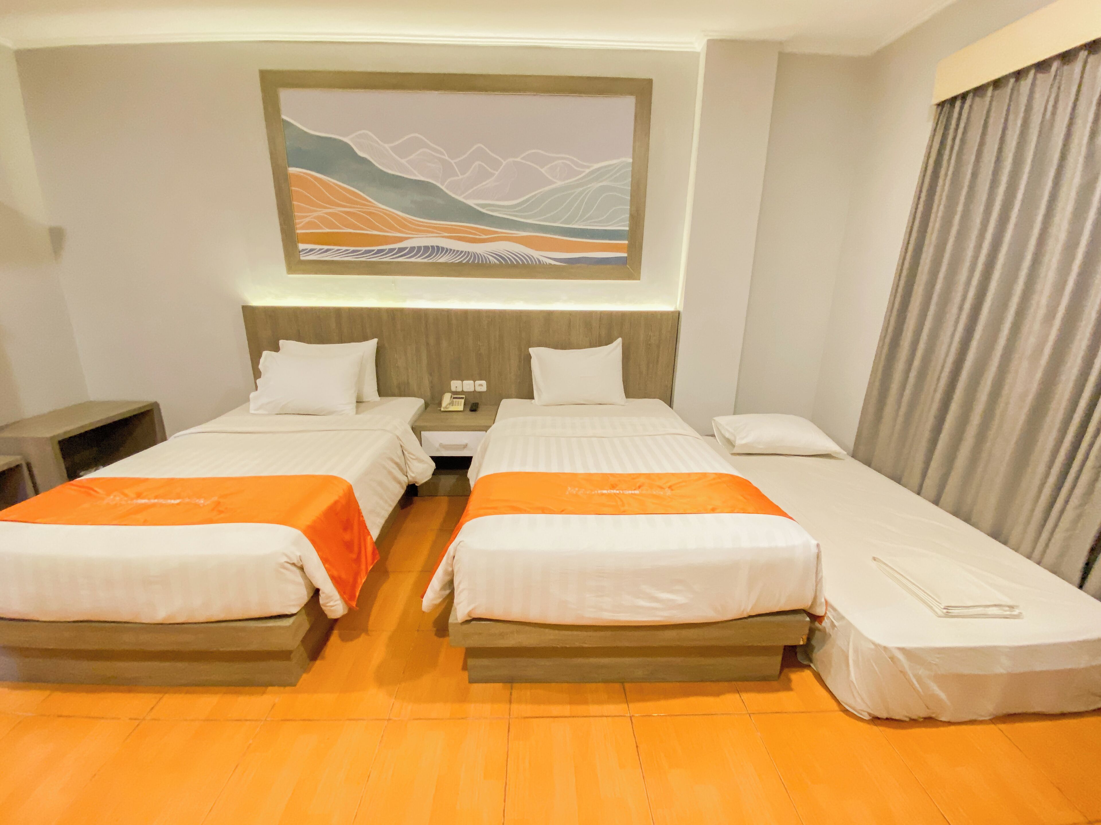 A hotel room with two single beds, a nightstand, a telephone, and a painting on the wall.