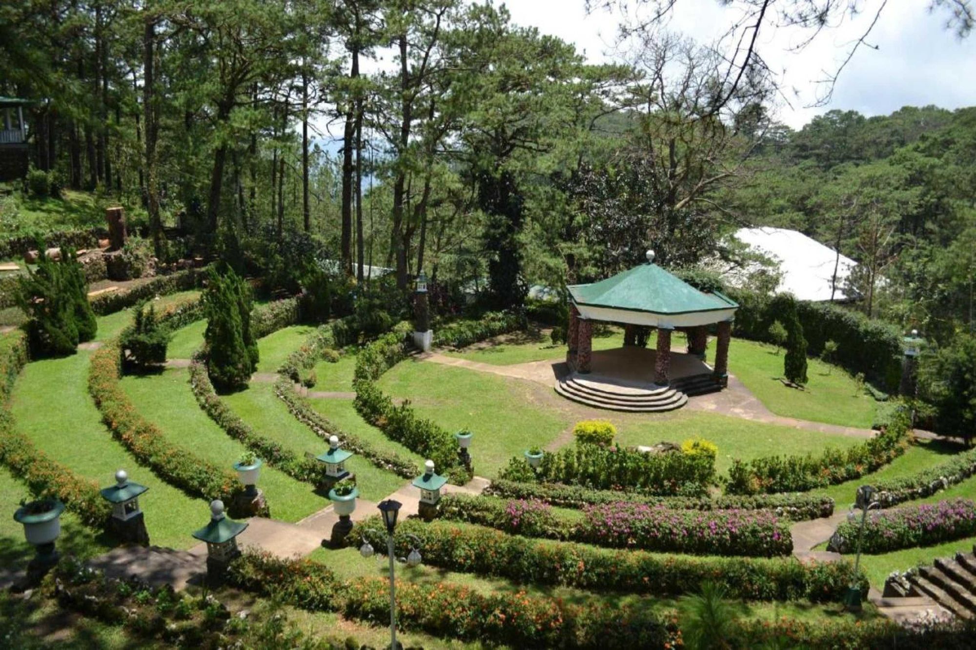 A garden with a gazebo, winding paths, and a variety of plants.