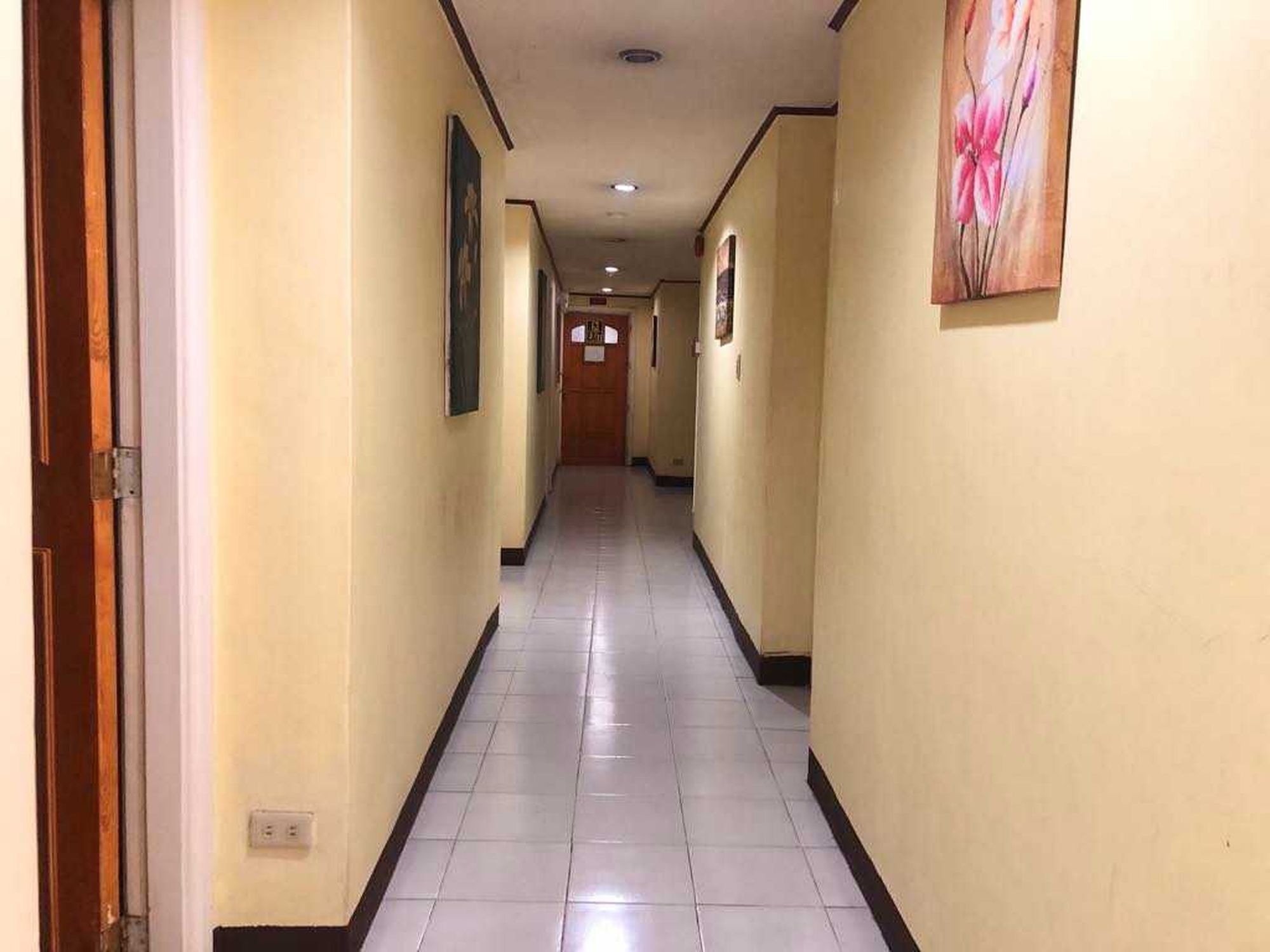 A long, narrow hallway with a tiled floor and cream-colored walls.