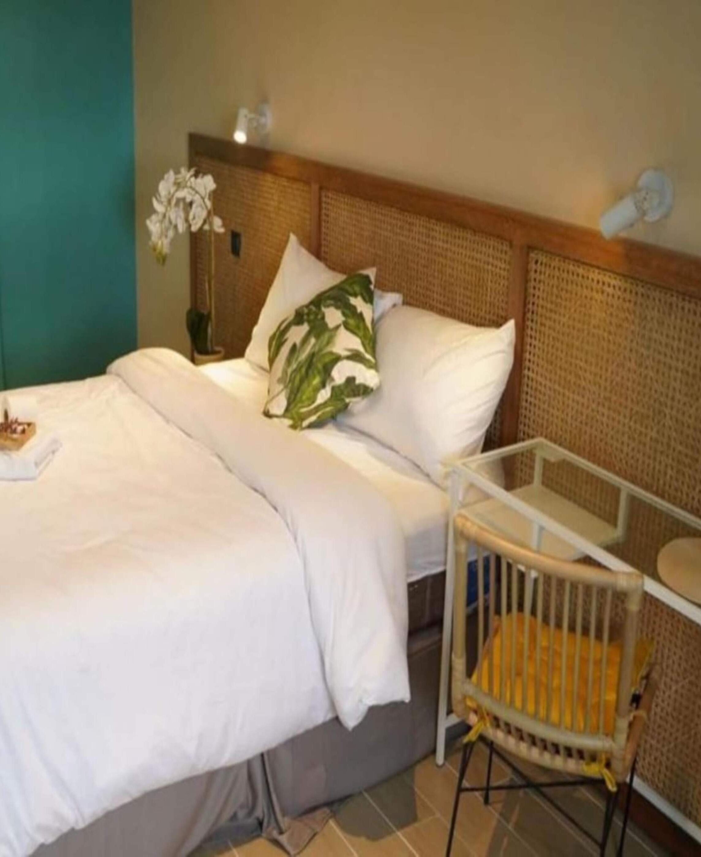 Une chambre d’hôtel avec un lit, un berceau et un luminaire fixé au mur.