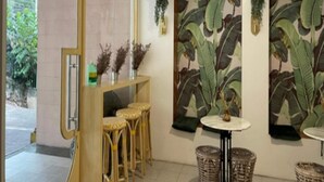 A room with a large mirror, wicker furniture, and tropical-themed wall art. - Marian Palazz Hotel (Baguio)