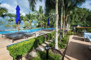 A poolside area with lounge chairs, a pool, and a view of the ocean. - Grande Sun Seaside Villas (Ko Chang)