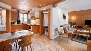 A wooden interior with a dining area, kitchen, and living space.