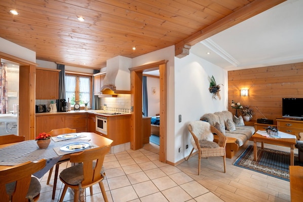 A wooden interior with a dining area, kitchen, and living space.