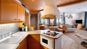 Una cucina compatta con lavello, fornelli e mobili in legno.