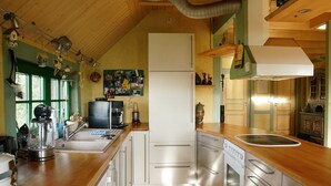 Une cuisine avec des meubles de rangement en bois, un évier en acier inoxydable et un four encastré.
