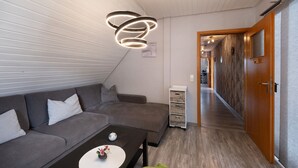 A modern living room with a sofa, a coffee table, and a unique circular light fixture.