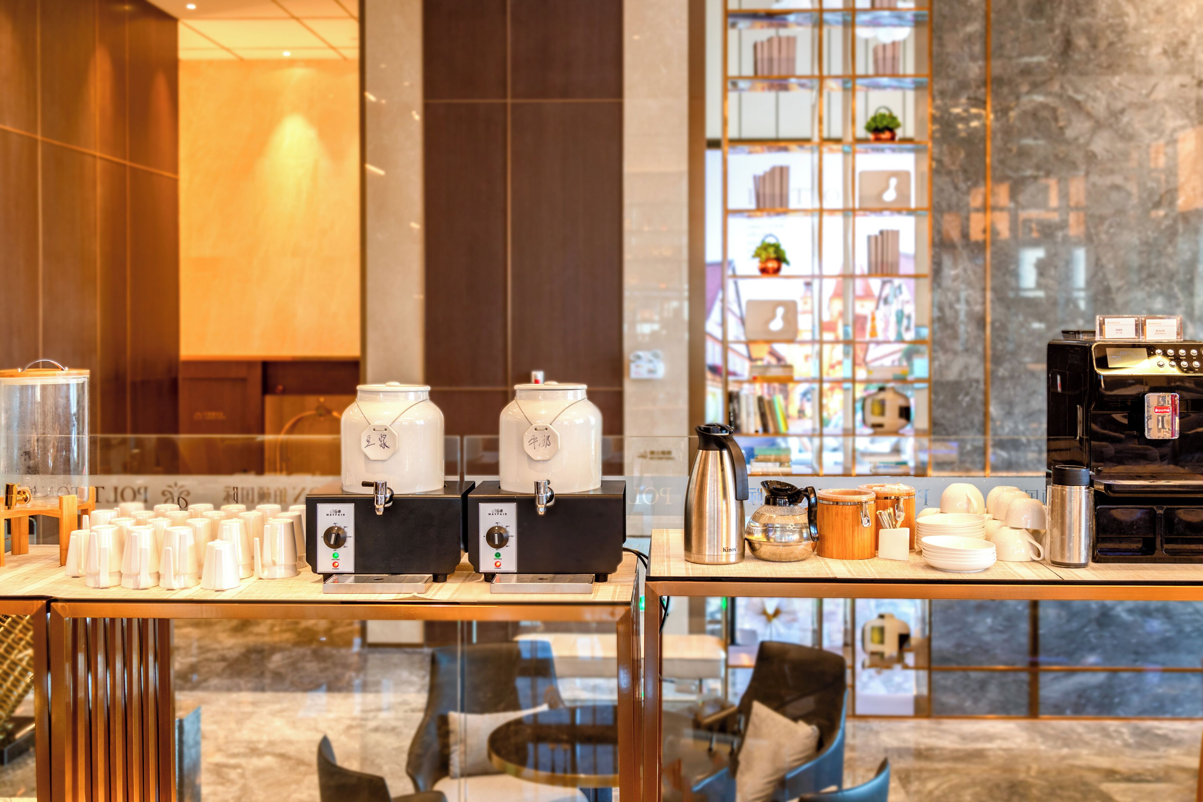 A coffee station with multiple coffee makers, a kettle, and various coffee cups and containers.