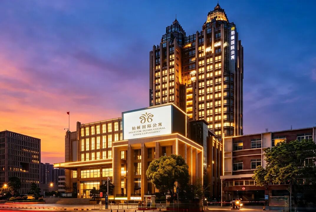 A modern hotel building with a prominent sign, surrounded by other high-rise buildings.