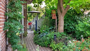 A brick building with a garden path leading to a covered area. - Apartment 'Inge Huus' with Private Terrace, Garden, and Wi-Fi (Hude)