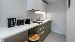 A compact kitchen with a white countertop, a coffee maker, a toaster, and a sink. - Central Bliss Suite D1 (Athens)