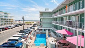 Ein Hotel mit Schwimmbad, Balkon und Blick sowie ein Schild mit der Aufschrift 'Four Winds'.