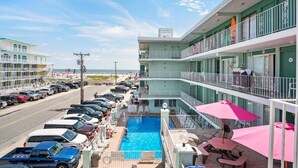 Un hôtel doté d’une piscine, d’un balcon avec vue et d’une enseigne indiquant « Les Quatre Vents ».