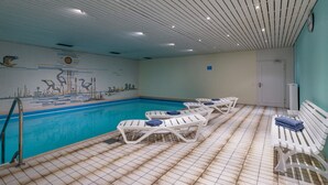 A swimming pool area with tiled flooring, lounge chairs, and a bench. - Vacation apartment Schanzenblick C8 (Oberaudorf)