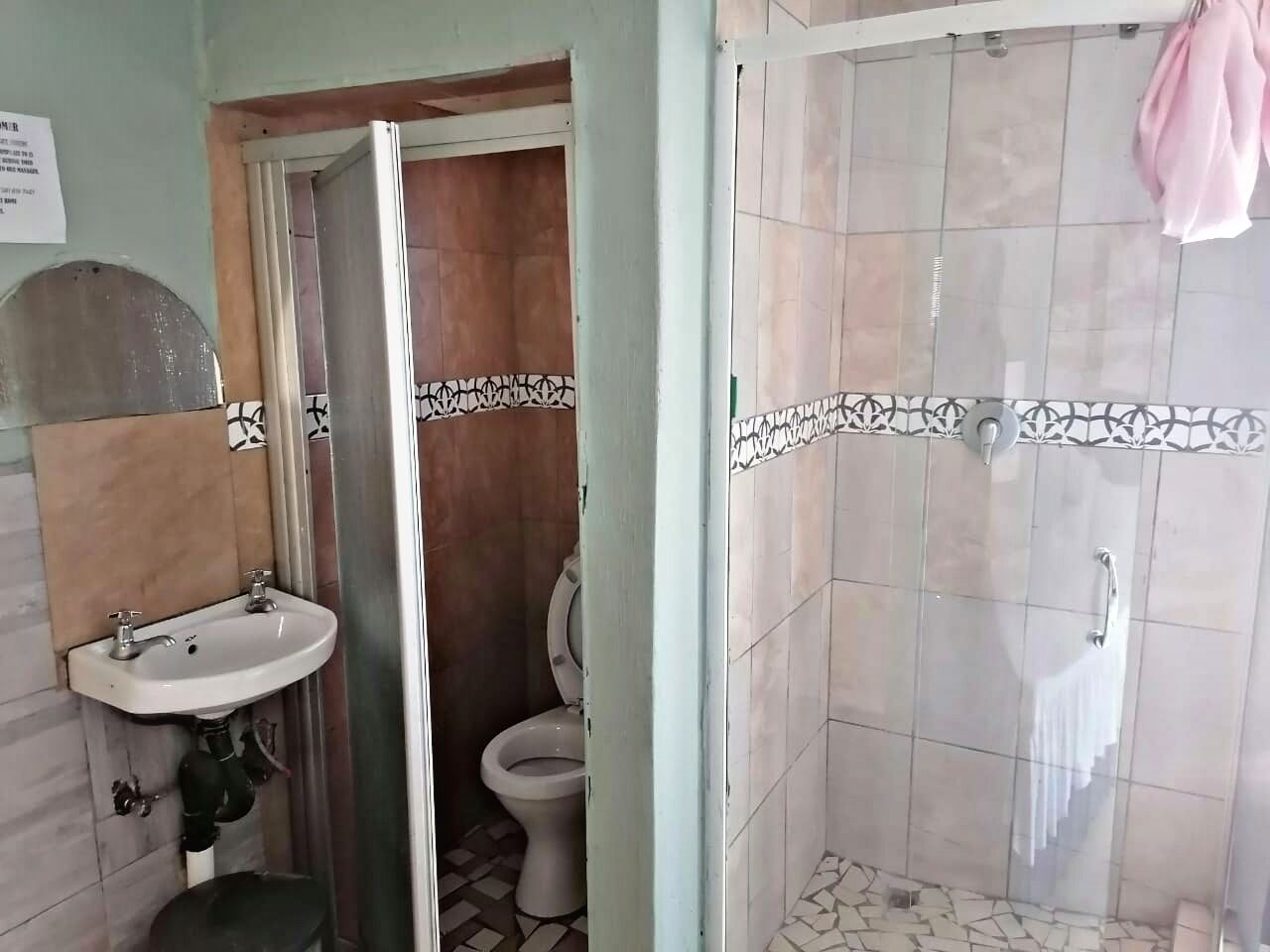 Une salle de bain comprenant un lavabo, des toilettes et un espace douche.