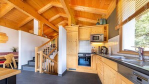 A modern kitchen with wooden cabinets, a microwave, and a stove.