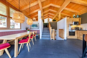 Een houten interieur met een eethoek, trap en keuken.