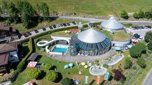 A resort with a swimming pool, a circular building, and a parking area.