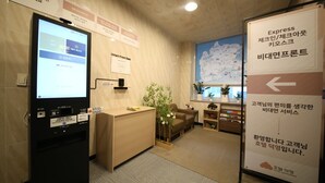 A reception area with a digital display, a desk, a map on the wall, and a sign indicating directions. - HOTEL DEOKYEONG (Wonju)