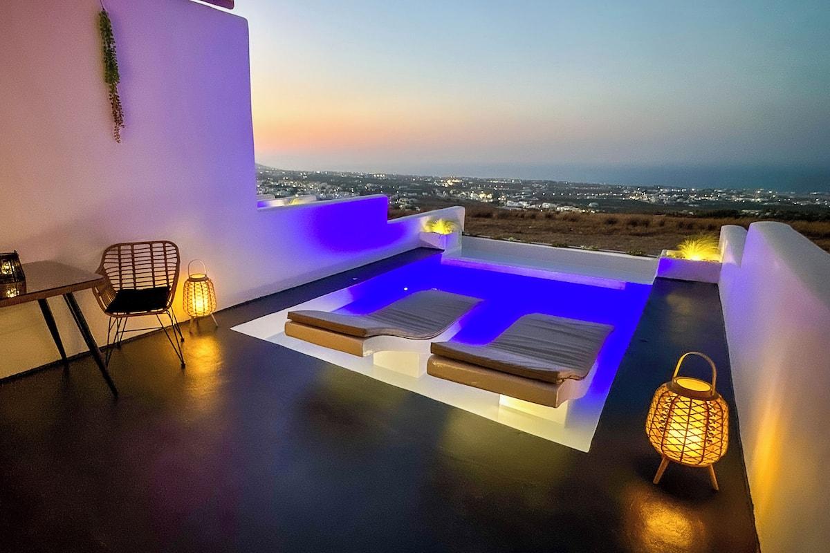 Una terraza en la azotea con zona de estar, una mesa y vistas a la ciudad al atardecer.