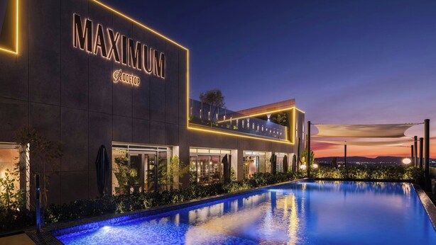 A modern hotel with a rooftop pool, named "MAXIMUM ROOFTOP," featuring a well-lit exterior and a clear view of the city skyline at dusk. - AC Hotel Santiago de los Caballeros (Santiago de los Caballeros)
