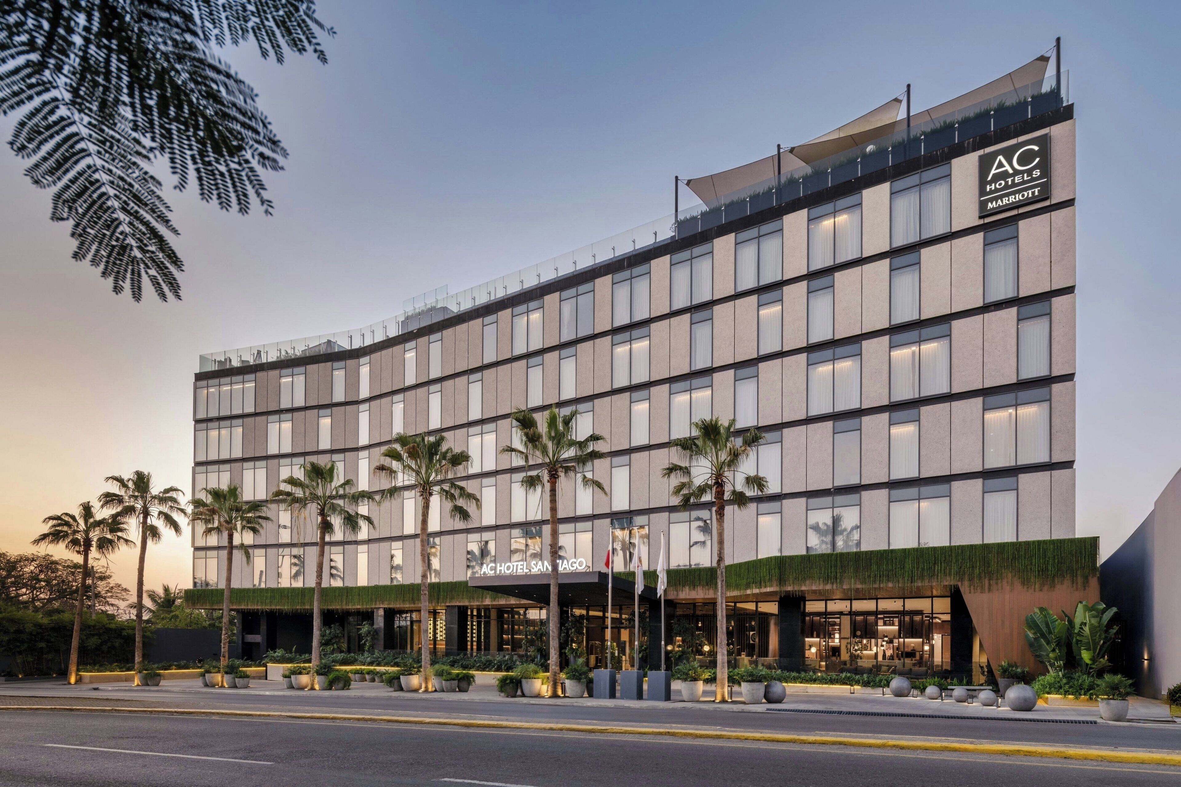 Um edifício moderno de hotel com fachada plana, grandes janelas e uma placa indicando ser um AC Hotel San Jose Marriott.
