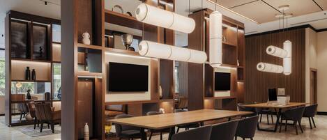 A modern conference room with a long table, chairs, and built-in shelving with decorative items.